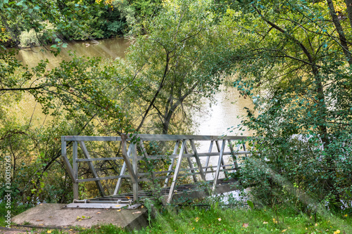 metal walkway to access jetty on the river with sun rays photo