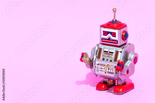 Antique tin toy robot on pink background. Vintage and classic concept free copy space for text.