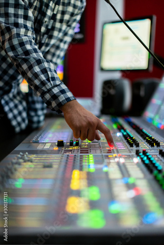 Male broadcast engineer works in studio