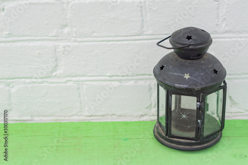 Old vintge black rusty lantern  on green shelf, home interior decoration photo