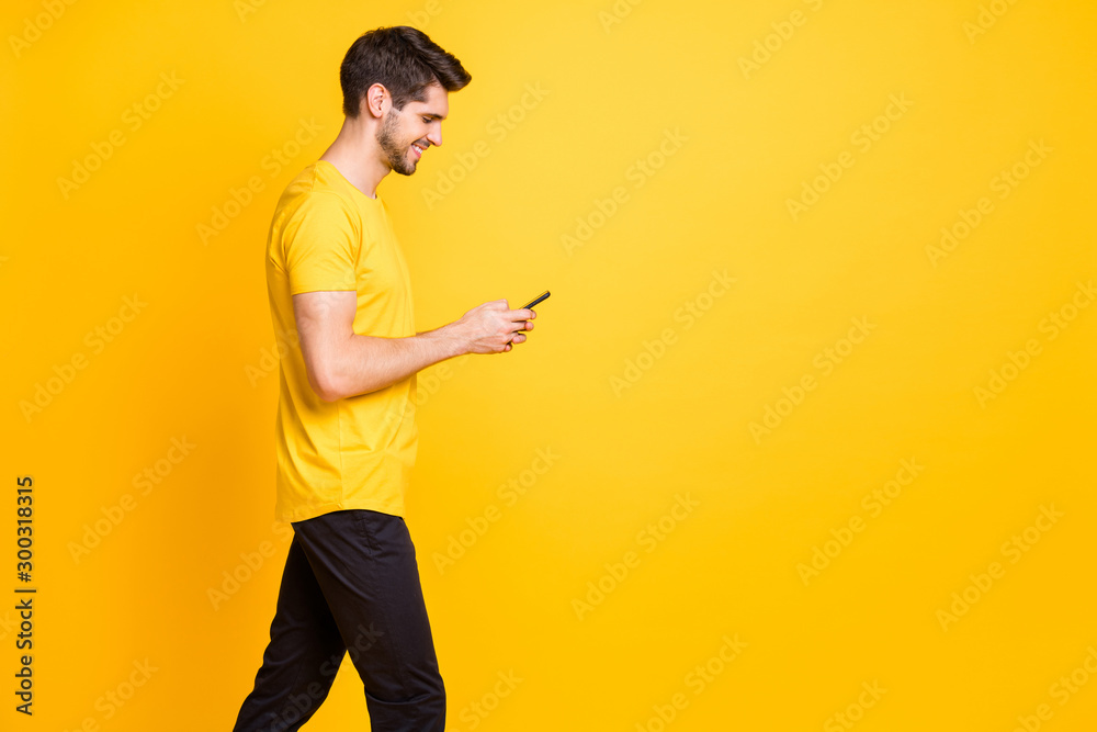Photo of cheerful trendy positive handsome attractive man addicted to browsing through his profile in social media wearing t-shirt black trousers isolated vivid color background Photo of cheerful trendy positive handsome attractive man addicted to browsing through his profile in social media wearing t-shirt black trousers isolated vivid color background