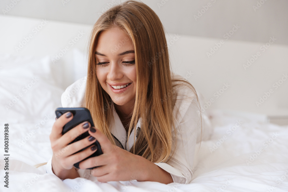 Photo of pretty joyful woman using cellphone and smiling Photo of pretty joyful woman using cellphone and smiling