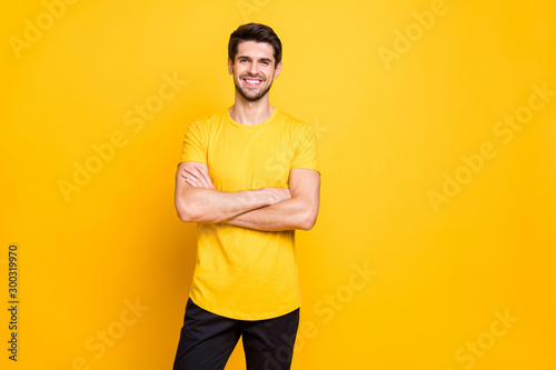 Portrait of his he nice attractive lovely cheerful cheery glad content guy wearing tshirt folded arms good mood isolated over bright vivid shine vibrant yellow color background