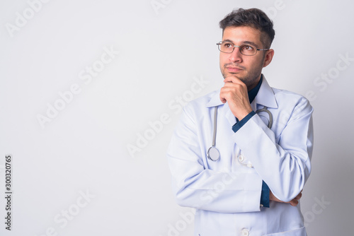 Portrait of young Persian man doctor thinking