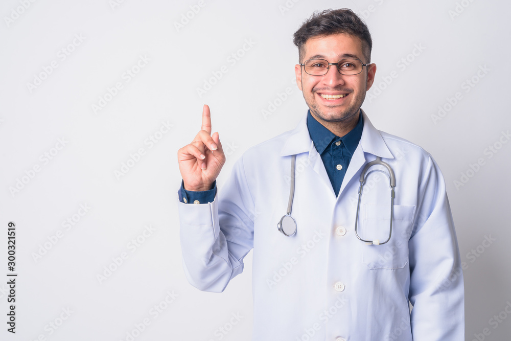 Portrait of happy Persian man doctor pointing up Portrait of happy Persian man doctor pointing up