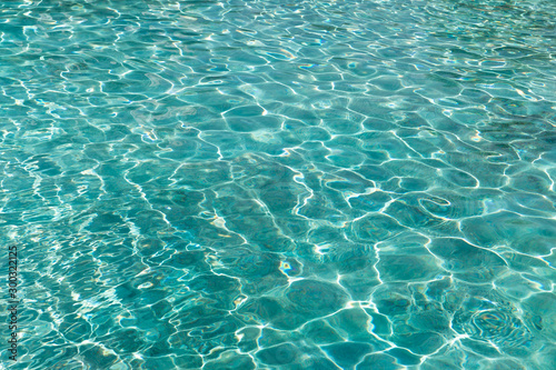 Turquoise blue water in swimming pool background, sun reflection, clear clean water, shining water ripple background, Aqua texture, pattern
