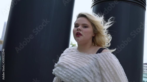 Attractive blonde girl dancing passionately in urban street, self-acceptance