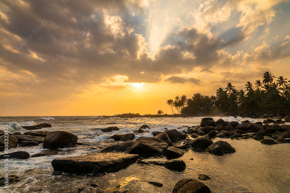 Romantic sunset on a tropical beach with palm trees