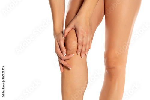 woman holding her painful knee on white background