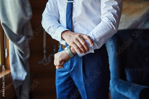 businessman checking time on his wrist watch, man putting clock on hand,groom getting ready in the morning before wedding ceremony. Men Fashion