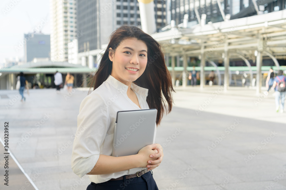 Professional business woman smiling holding laptop working to outdoor city. Professional business woman smiling holding laptop working to outdoor city.