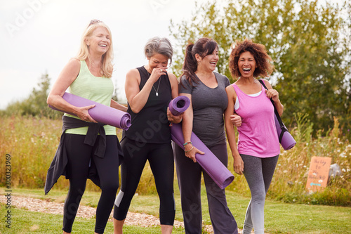 Tablou pe pânză Group Of Mature Female Friends On Outdoor Yoga Retreat Walking Along Path Throug