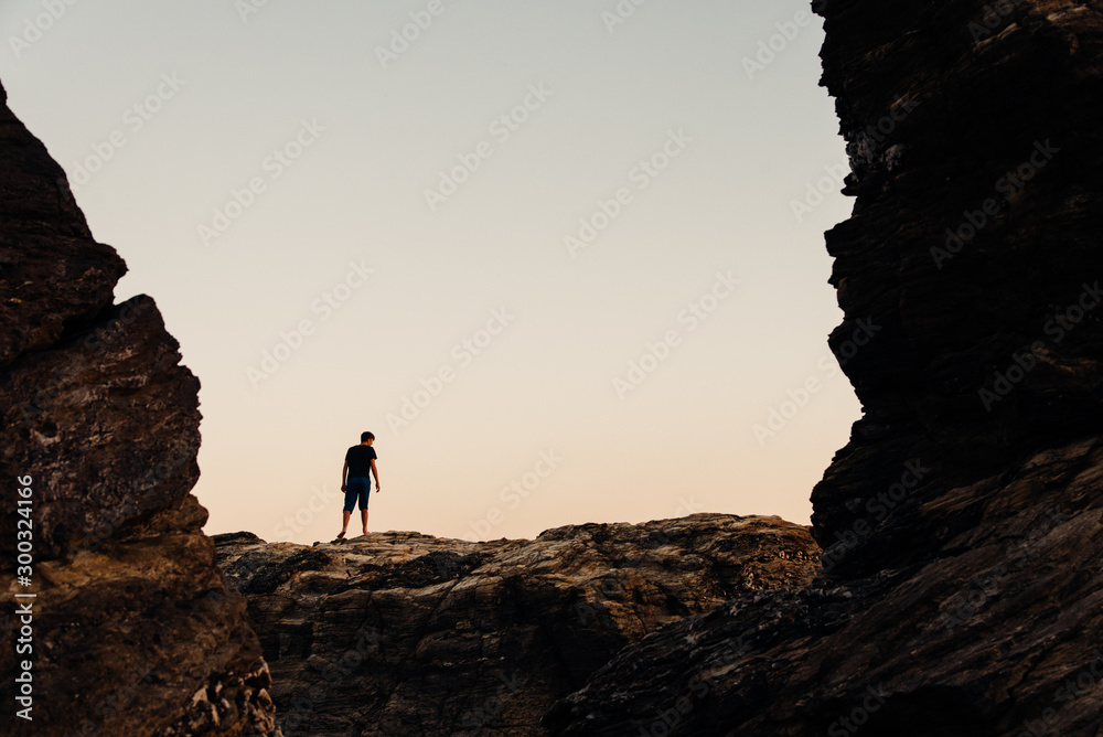 la silhouette d'un homme entre 2 rochers