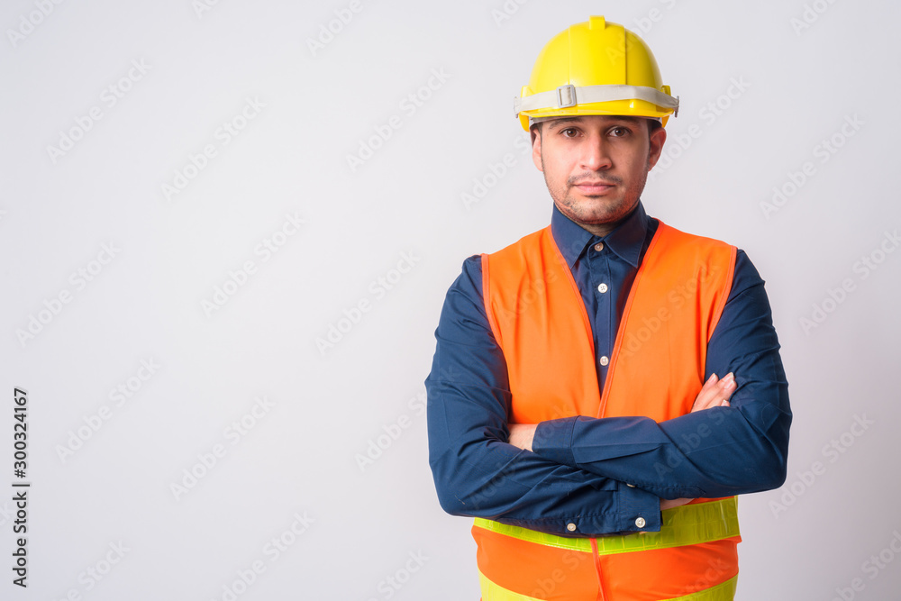 Portrait of young Persian man construction worker with arms crossed Portrait of young Persian man construction worker with arms crossed