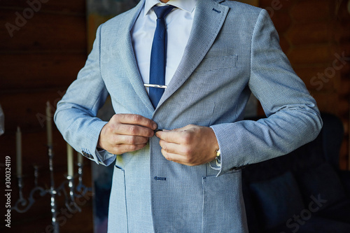 Businessman wears a jacket,male hands closeup,groom getting ready in the morning before wedding ceremony