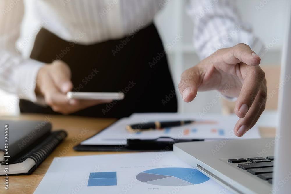 Business women using smartphone to checking the company performance chart in the office. Business concept. Business women using smartphone to checking the company performance chart in the office. Business concept.