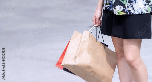 Shopping Concept; Business woman's hand is holding shopping bags in one hand at shopping mall after hard work
