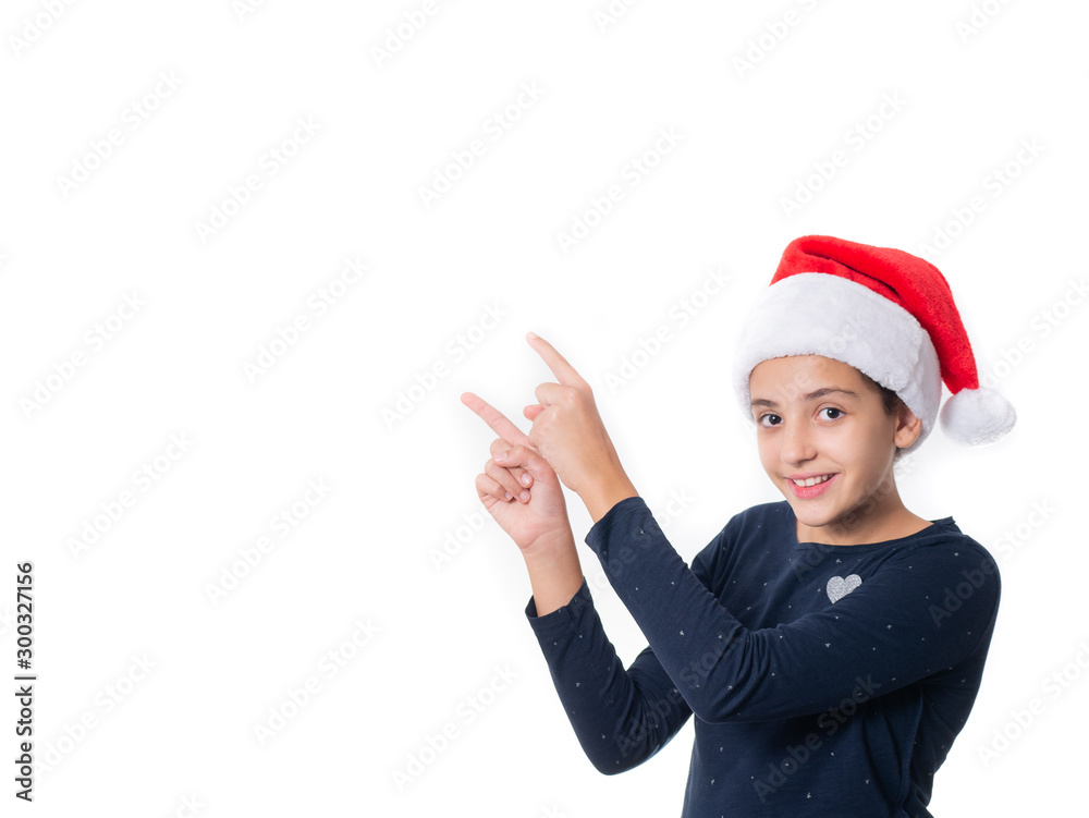 young girl wearing a Santa hat and pointing at something isolated on white background young girl wearing a Santa hat and pointing at something isolated on white background