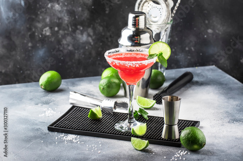 Watermelon margarita, alcoholic cocktail with silver tequila, lime juice, mint, watermelon and crushed ice, metal bar tools, gray background photo