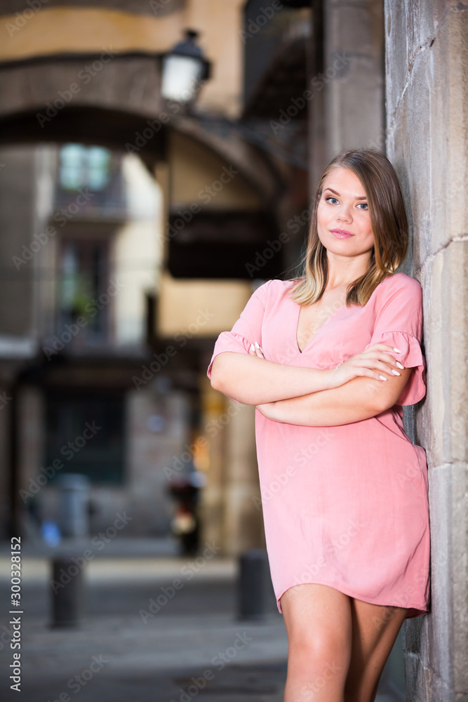 Young smiling woman near the stone wall  in historical center