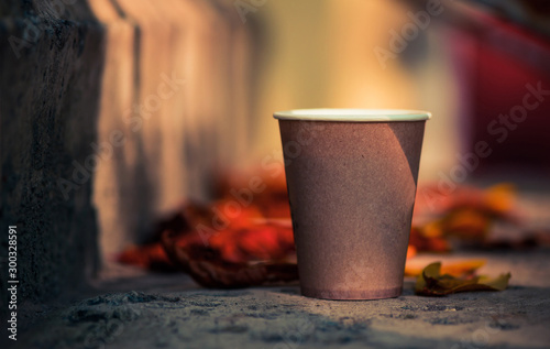 paper coffee cup at fall season faded leafs background