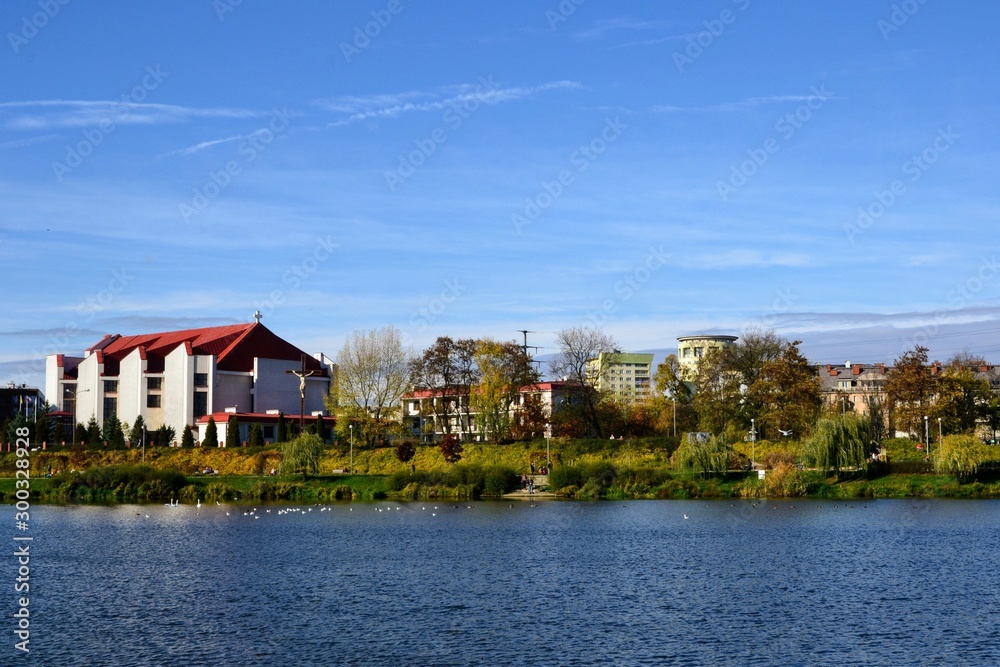 Obraz premium Balaton Lake in Warsaw, Poland. Park and water reservoir located in Warsaw city. View on the Church of Apostles John and Paul. Panoramic view