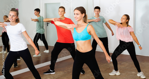 Teenage dancers practicing active vigorous dance in modern studi