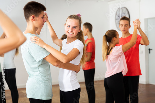 Teens in pairs learning to dance waltz