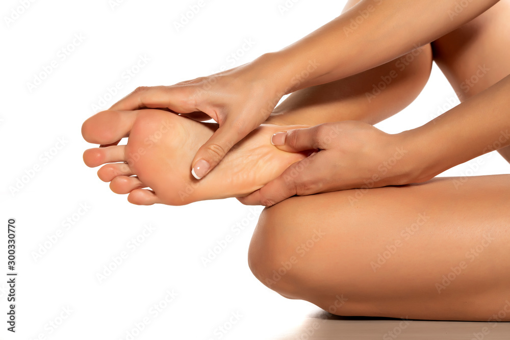 woman massaging her painful foot on white background