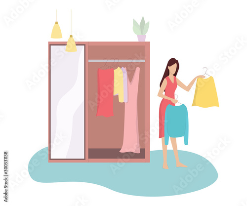 Young woman choosing between two clothes. Girl in doubt