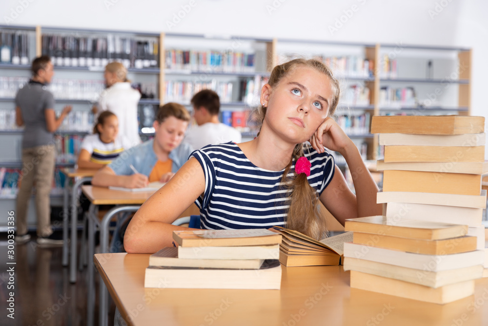 Bored teenage girl in library - obrazy, fototapety, plakaty 