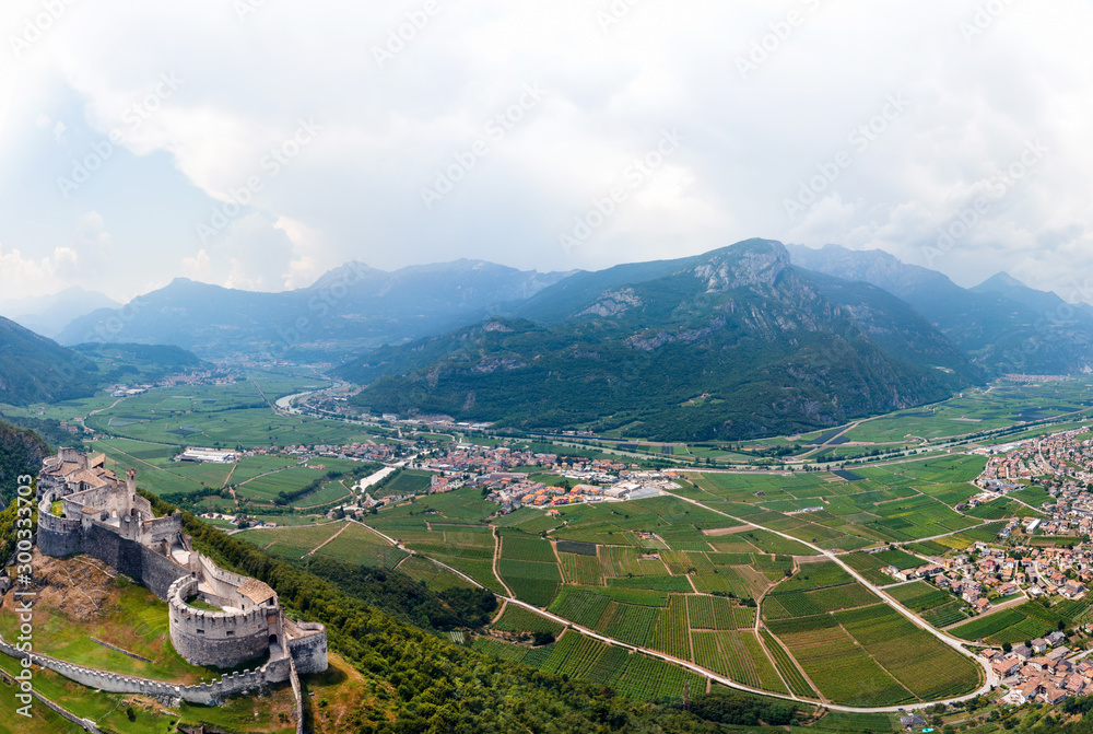 Aerial view of Beseno Castle and northern vineyards, the largest fortified structure in Besenello, Trento, Italy. wide panorama with high resolution, touristic place in Europe