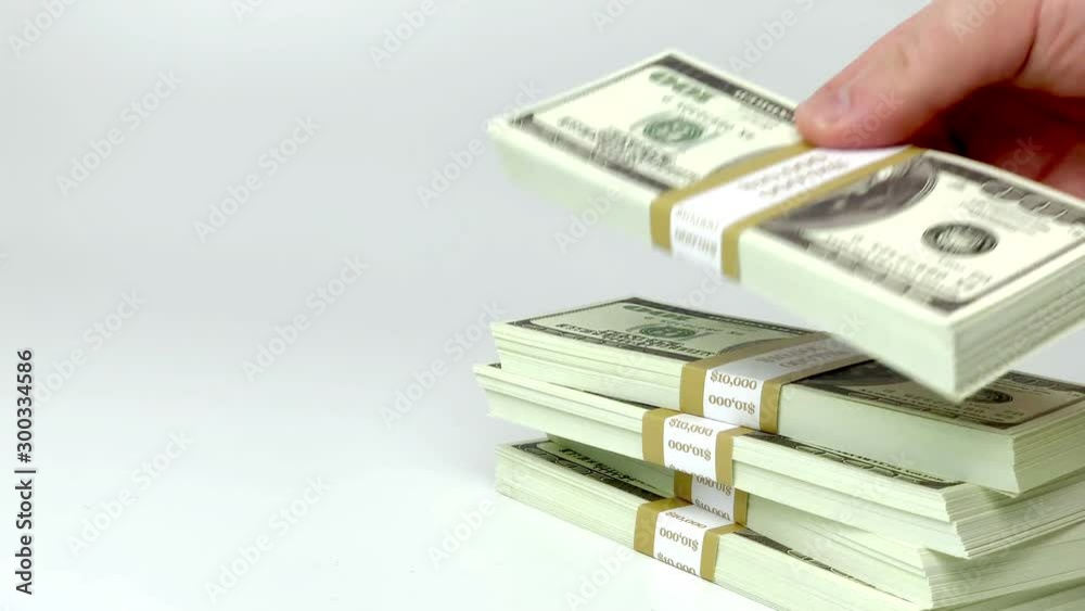 Investing funds, economics transaction and wealthy millionaire counting money conceptual idea with hand that stacks wads of 100 american dollar bills isolated on white background with copy space