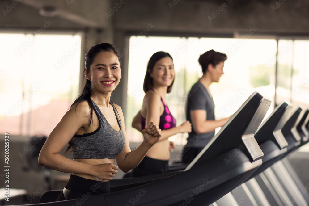 Happy friends run exercise on treadmills Happy friends run exercise on treadmills
