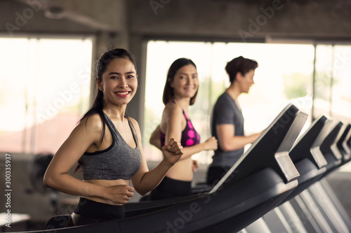 Happy friends run exercise on treadmills