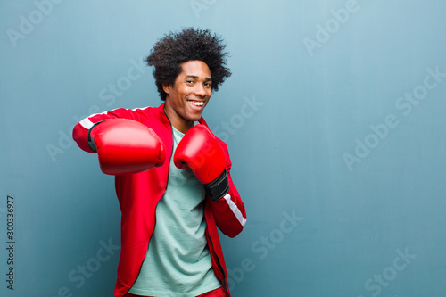 young black man with boxing gloves against blue grunge wall photo