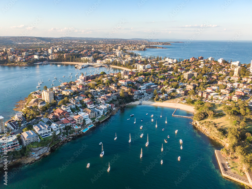 Aerial drone evening view of Manly, a beach-side suburb of northern Sydney in the state of New South Wales, Australia. Little Manly Beach in the foreground, Manly Harbour & Manly Beach in background. 
