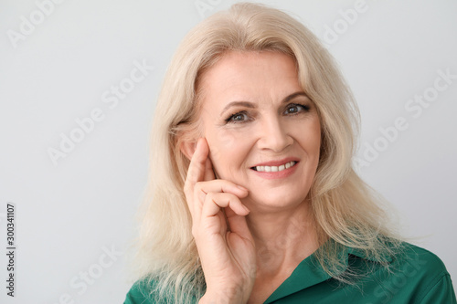 Portrait of beautiful mature woman on light background