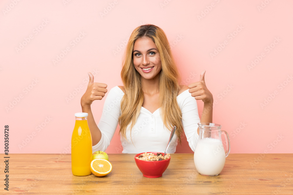 Young blonde woman having breakfast milk giving a thumbs up gesture Young blonde woman having breakfast milk giving a thumbs up gesture