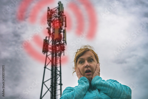 Woman is holding her head near the 5G BTS