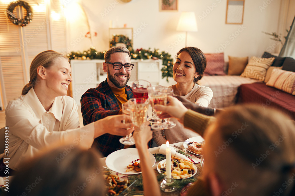 © Seventyfour - High angle portrait of cheerful adult people clinking champagne glasses while enjoying Christmas dinner at home, copy space © Seventyfour - High angle portrait of cheerful adult people clinking champagne glasses while enjoying Christmas dinner at home, copy space