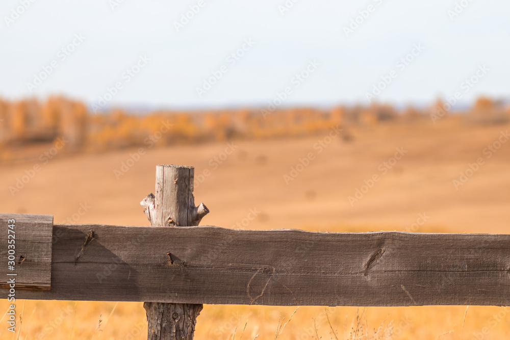 Old wooden fence on the background of autumn fields, forests and mountains Old wooden fence on the background of autumn fields, forests and mountains