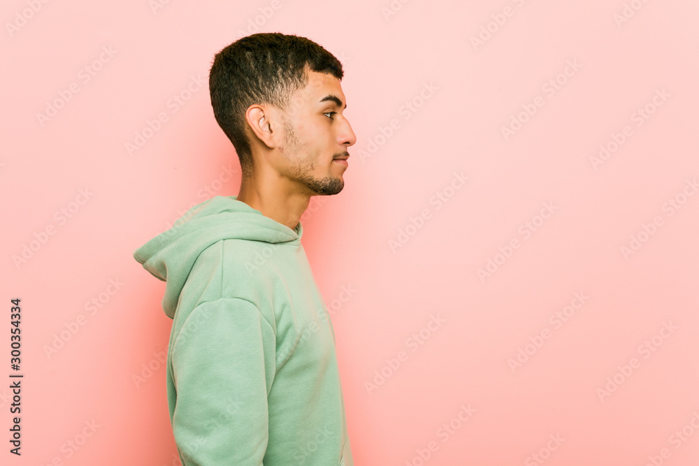 Young hispanic sport man gazing left, sideways pose.