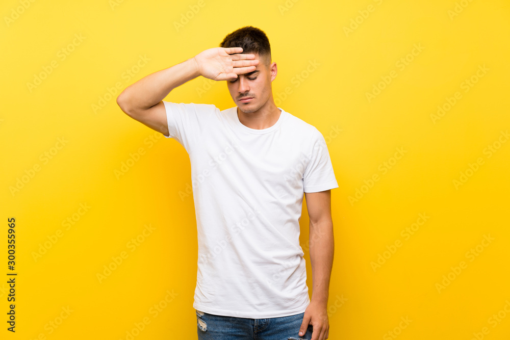 Young handsome man over isolated yellow background with tired and sick expression Young handsome man over isolated yellow background with tired and sick expression