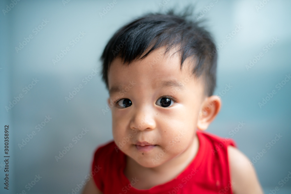 Baby boy wear red vest shirt plying in cozy room Baby boy wear red vest shirt plying in cozy room