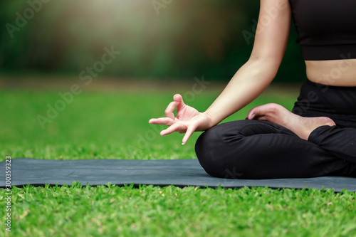 Young Asian woman practicing yoga pose at the park in morning