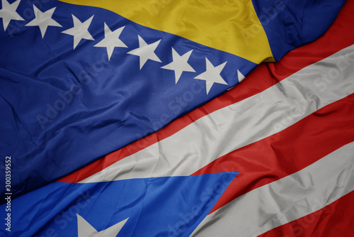 waving colorful flag of puerto rico and national flag of bosnia and herzegovina.