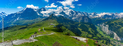 Hiking trail to summit of mountain Mannlichen, popular viewpoint in Swiss Alps, Switzerland. Eiger, Monch and Jungfrau, Lauterbrunnen in background.