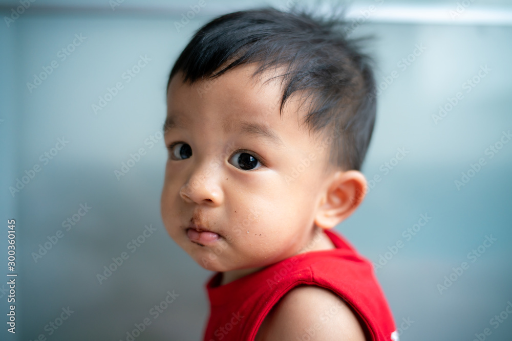 Baby boy wear red vest shirt plying in cozy room Baby boy wear red vest shirt plying in cozy room