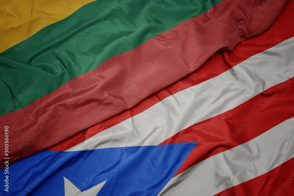 waving colorful flag of puerto rico and national flag of lithuania.
